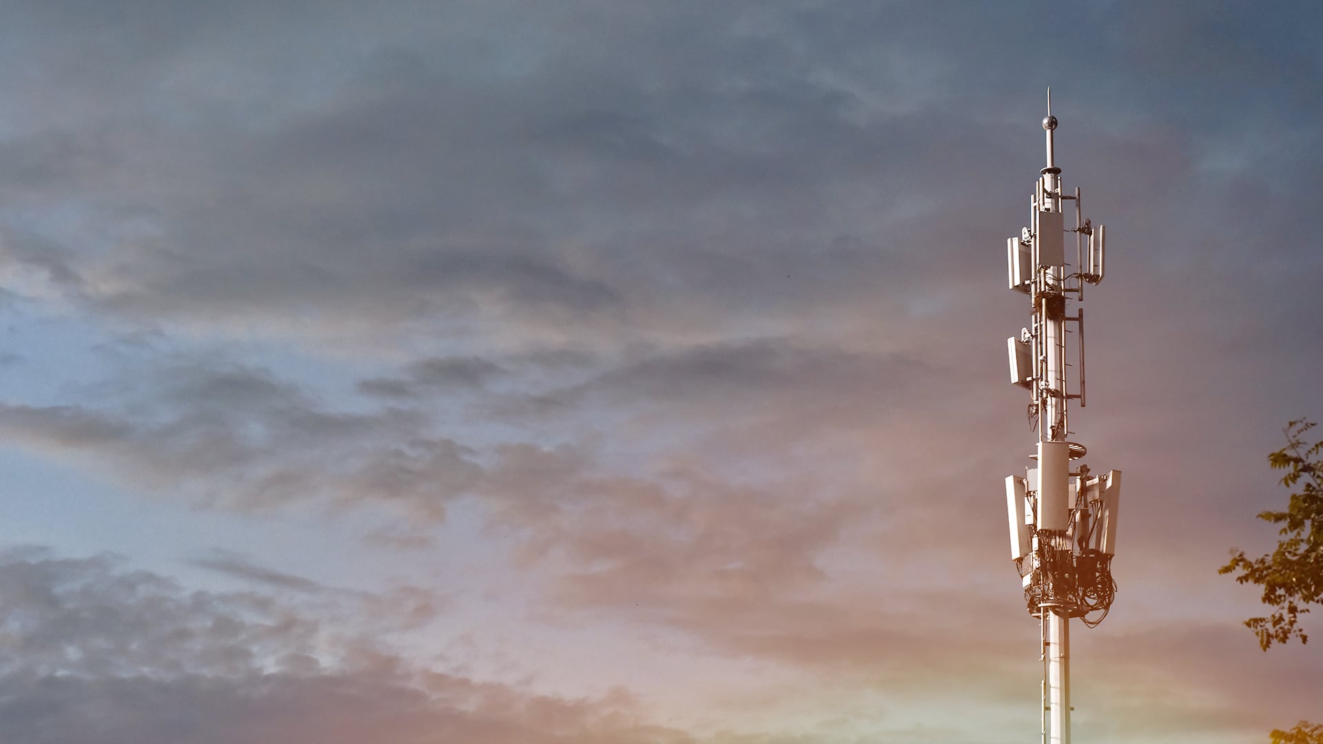 Bild på en telefonmast mot en molnig himmel.